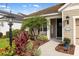 Landscaped front yard featuring tropical plants, mulch, and a welcoming front porch with lovely curb appeal at 12261 Stuart Dr, Venice, FL 34293
