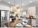 Bright kitchen featuring white cabinetry, granite countertops, an island with barstools, and stainless steel appliances at 12261 Stuart Dr, Venice, FL 34293