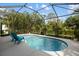 A serene swimming pool and lush tropical backyard create a relaxing outdoor oasis at 12261 Stuart Dr, Venice, FL 34293
