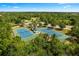 Aerial shot of tennis courts surrounded by trees, landscaping, and a parking lot with blue playing surfaces at 12261 Stuart Dr, Venice, FL 34293