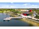Aerial view of waterfront area with dock and watercraft, set against a backdrop of attractive community buildings at 12261 Stuart Dr, Venice, FL 34293