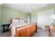 A serene bedroom offers light green walls, a ceiling fan, closet space, and a comfortable atmosphere at 1299 Tripoli, North Port, FL 34286