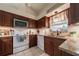 Well-appointed kitchen with dark wood cabinets, granite countertops, and modern appliances at 1299 Tripoli, North Port, FL 34286
