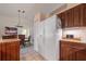 Spacious kitchen with wood cabinetry, a white refrigerator, and dining area in the background at 1299 Tripoli, North Port, FL 34286