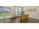 Modern dining area featuring stylish yellow chairs, a glass table, and sliding doors to an outdoor seating area at 13113 Bayberry Way, Parrish, FL 34219