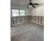 A bedroom awaits renovation with visible block, updated ceiling fan, and natural light at 13434 1St St E, Madeira Beach, FL 33708