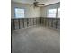An unfinished bedroom featuring two bright windows and a ceiling fan at 13434 1St St E, Madeira Beach, FL 33708