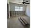 A bedroom awaits renovation with visible block, updated ceiling fan, and new flooring at 13434 1St St E, Madeira Beach, FL 33708