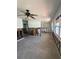 An expansive living room awaits renovation with visible studs and updated ceiling fan at 13434 1St St E, Madeira Beach, FL 33708