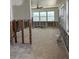 A large living room awaits renovation and finishing with bright, natural light and tile flooring at 13434 1St St E, Madeira Beach, FL 33708