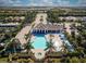 Breathtaking aerial view of community pool, clubhouse and surrounding neighborhood lined with palm trees and lush greenery at 13513 Deep Blue Pl, Bradenton, FL 34211