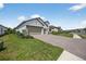 Stunning home featuring a paver driveway and three-car garage, complemented by lush landscaping and manicured lawn at 13513 Deep Blue Pl, Bradenton, FL 34211