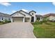 Inviting home featuring a large driveway, manicured lawn, and beautiful architectural details at 13513 Deep Blue Pl, Bradenton, FL 34211