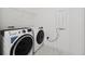 A bright laundry room featuring a modern washer and dryer set and a wire rack for storage at 13513 Deep Blue Pl, Bradenton, FL 34211