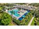 An inviting community pool features a sundeck, umbrellas, and plenty of seating surrounded by lush greenery at 13513 Deep Blue Pl, Bradenton, FL 34211