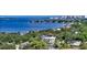 Expansive aerial shot showcasing a modern home nestled amidst mature trees with bay views at 1610 N Lodge Dr, Sarasota, FL 34239