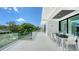 Spacious balcony with outdoor dining, glass railings, a spiral staircase, and lush greenery views at 1610 N Lodge Dr, Sarasota, FL 34239