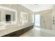 Spacious bathroom featuring a walk-in shower, dual sink vanity with LED-lit mirrors, and elegant marble accents at 1610 N Lodge Dr, Sarasota, FL 34239