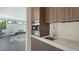 Contemporary butler pantry featuring sleek cabinetry, marble countertops, stainless sink and designer coffee maker at 1610 N Lodge Dr, Sarasota, FL 34239