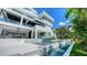 Stunning modern home exterior with a pool, sleek white finishes, and lush tropical landscaping, creating a serene oasis at 1610 N Lodge Dr, Sarasota, FL 34239