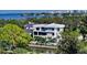 Luxury waterfront estate features a modern white facade, private canal access, and lush tropical landscaping at 1610 N Lodge Dr, Sarasota, FL 34239