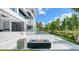 Modern outdoor patio includes a fire pit, sleek white design, and tropical landscaping for serene relaxation at 1610 N Lodge Dr, Sarasota, FL 34239