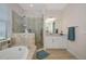 Bright bathroom featuring a large soaking tub, a glass enclosed shower, and a white vanity at 16231 Tradewind Ter, Bradenton, FL 34211