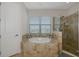 This bathroom features a large soaking tub, a glass enclosed shower, and a window with views at 16231 Tradewind Ter, Bradenton, FL 34211
