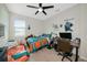 Bedroom with two beds, ceiling fan, and lots of natural light and sporty decor at 16231 Tradewind Ter, Bradenton, FL 34211
