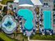 Aerial view showcasing a community pool with distinct activity zones and plenty of lounge chairs with umbrellas at 16231 Tradewind Ter, Bradenton, FL 34211