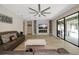 Spacious living room features a cozy fireplace, stylish ceiling fan, and a sliding glass door to the lanai at 16231 Tradewind Ter, Bradenton, FL 34211