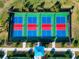 Aerial view of four pickleball courts with red and blue surfaces, enclosed by fencing at 16231 Tradewind Ter, Bradenton, FL 34211