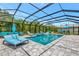 The in-ground pool and spa area is screened and surrounded by seating at 16231 Tradewind Ter, Bradenton, FL 34211