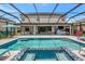 The screened pool and spa overlook a patio and the home's backyard at 16231 Tradewind Ter, Bradenton, FL 34211