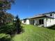 Spacious backyard featuring a lush green lawn, and a covered patio, perfect for outdoor relaxation and entertainment at 17134 Savory Mist Cir, Bradenton, FL 34211