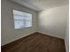A well-lit bedroom featuring wood flooring and a window at 17134 Savory Mist Cir, Bradenton, FL 34211
