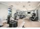A community fitness center with modern equipment, ceiling fans, and natural light from the windows at 17134 Savory Mist Cir, Bradenton, FL 34211