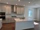 Modern kitchen featuring an island with a marble countertop, stainless steel appliances, and gray cabinets, offering a sleek and functional space at 17134 Savory Mist Cir, Bradenton, FL 34211