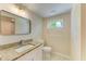 Bathroom with vanity, granite countertop, framed mirror, and natural light from a window at 2026 Arkansas Ave, Englewood, FL 34224