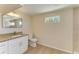 Bright bathroom featuring a granite countertop, white cabinets and wood look flooring at 2026 Arkansas Ave, Englewood, FL 34224