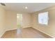 This bedroom features light, neutral walls, a window with pleated shades, and wood-look laminate flooring at 2026 Arkansas Ave, Englewood, FL 34224