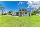 Well-manicured lawn surrounds this cozy home with a screened porch and neatly maintained exterior at 2026 Arkansas Ave, Englewood, FL 34224