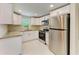 The kitchen offers new stainless steel appliances and white cabinets at 2026 Arkansas Ave, Englewood, FL 34224