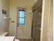 Bathroom featuring a toilet, walk-in shower with glass doors, and an exterior door at 22321 Yonkers Ave, Port Charlotte, FL 33952