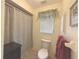 Bathroom featuring a white toilet, shower with curtain, and a valance above the window at 22321 Yonkers Ave, Port Charlotte, FL 33952