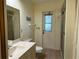 Bright bathroom featuring a vanity, toilet, shower with glass door, and exterior access door at 22321 Yonkers Ave, Port Charlotte, FL 33952