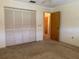 Simple bedroom with a closet, neutral carpeting, and a door leading to other parts of the home at 22321 Yonkers Ave, Port Charlotte, FL 33952