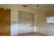 Neutral bedroom featuring a closet with louvered doors, a window and an adjacent door at 22321 Yonkers Ave, Port Charlotte, FL 33952