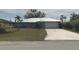 Charming single-story home featuring a lush lawn, a metal roof, and an attached two-car garage at 22321 Yonkers Ave, Port Charlotte, FL 33952