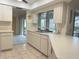 Kitchen features white cabinets, tile flooring, and a window view to outside at 22321 Yonkers Ave, Port Charlotte, FL 33952